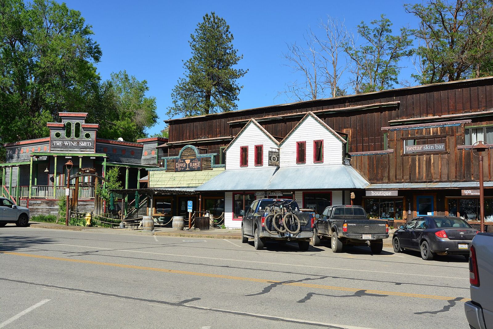 Wooden western-style storefronts on Riverside Avenue in Winthrop with trees and blue sky
